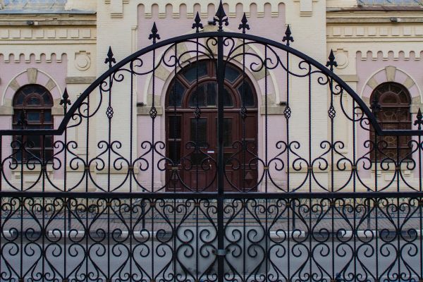 ornamental metal fence gate in front of a mission