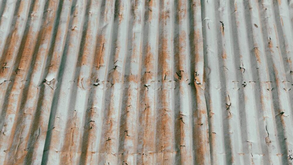 rust on corrugated metal, indicating that it is ferrous rather than non-ferrous