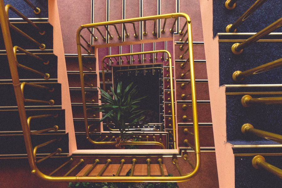 overhead view of staircase with railings made from brass bars