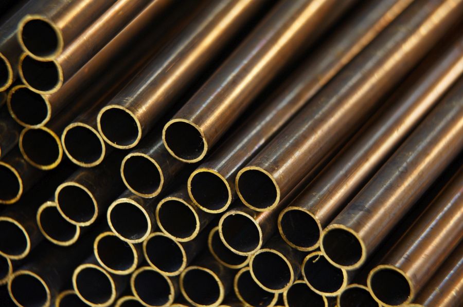 unfinished brass pipes stacked in a warehouse