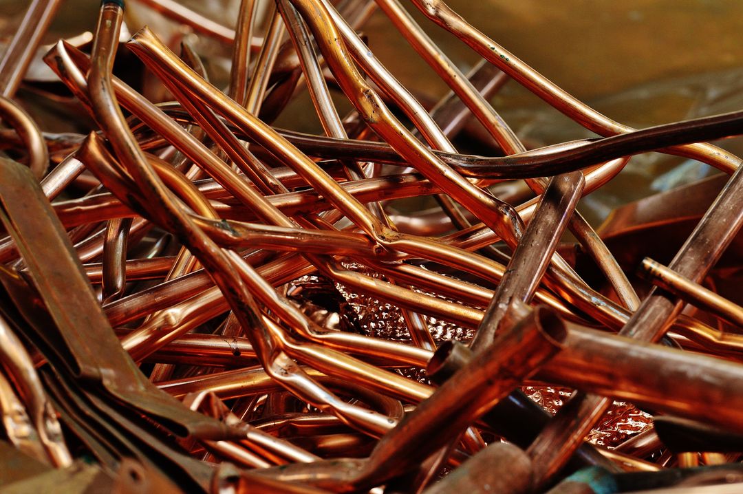 a pile of scrap red brass pipes